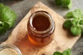 A jar of homemade herbal syrup for common cold, made from fresh Plectranthus amboinicus plant