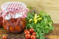 Jar of homemade ketchup and cherry tomato next to fresh cherry tomato Royalty Free Stock Photo