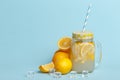 A jar of homemade lemonade and lemons on a blue background Royalty Free Stock Photo