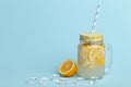 A jar of homemade lemonade and lemons on a blue background Royalty Free Stock Photo