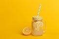 A jar of homemade lemonade and lemons on a yellow background Royalty Free Stock Photo