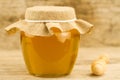 Jar of honey closed jute cloth drizzler on wooden background