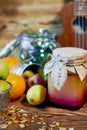 A jar of honey in the middle of citrus, lit garland.The warm atmosphere of the holidays. And vitamins during illness Royalty Free Stock Photo