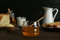 Jar with honey, milk, bread and butter on wooden table Royalty Free Stock Photo