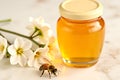 A jar of honey is on a table next to a bee Royalty Free Stock Photo