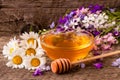 Jar of honey with wildflowers and chamomile on old wooden background Royalty Free Stock Photo