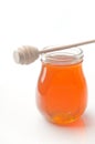 Jar of honey with wooden drizzler