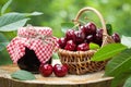 Jar of jam and basket of sweet cherries in garden outdoors Royalty Free Stock Photo