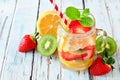 Jar of lemon, strawberry, kiwi detox water against blue wood Royalty Free Stock Photo