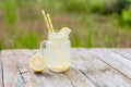 Jar with lemon water and lemon on wooden table. Cocktail. Summer relax. Copy space. Royalty Free Stock Photo