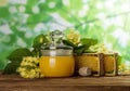 In jar with lid fresh honey, next to honeycomb and flowers on wooden table Royalty Free Stock Photo