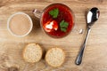 Jar with liver pate, transparent bowl with borsch, slices of bread, spoon on table. Top view