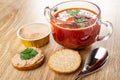 Jar with liver pate, bowl with borscht, slice of bread, sandwich with meat pate, spoon on table