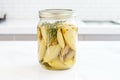 jar of marinated artichoke hearts on a white marble countertop Royalty Free Stock Photo