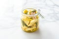 jar of marinated artichoke hearts on a white marble countertop Royalty Free Stock Photo