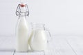 Jar with milk and vintage bottle of milk on white wooden table Royalty Free Stock Photo