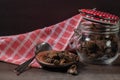 Jar with mushrooms, a dish towel and dried pine mushrooms in a small plate on a table Royalty Free Stock Photo