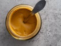 Jar of mustard with a silver spoon Royalty Free Stock Photo