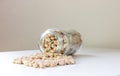 Jar of non-perishable cooked chick peas with dried chick peas spilled on the table