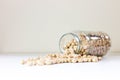 Jar of non-perishable dried chick peas spilled on a white table - preserved for Covid-19