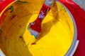 A jar of old yellow paint with a dirty brush in it .Can of yellow paint and brush. Top view Royalty Free Stock Photo