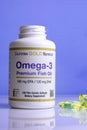 A jar of omega 3 vitamins, vitamins are on the table, a wooden spoon with omega 3 vitamins on a blue background, the concept of a