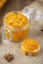 A jar of orange confiture and piece of French baguette with star anise