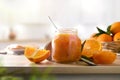 Jar of orange jam with fruit on wooden kitchen bench Royalty Free Stock Photo