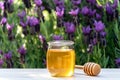 Jar of organic floral honey with a drizzle against lavender background . Outdoor Royalty Free Stock Photo