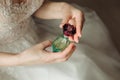 Jar of perfume in the hands of the bride. Beautiful wedding manicure.Hands closeup. Wedding morning bride Royalty Free Stock Photo