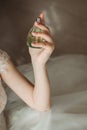 Jar of perfume in the hands of the bride. Beautiful wedding manicure.Hands closeup. Wedding morning bride Royalty Free Stock Photo