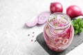 Jar of pickled onions on marble table Royalty Free Stock Photo