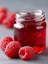A jar of raspberry jam with raspberries on a table Royalty Free Stock Photo