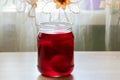 Jar with red paint and eggs in it, preparation for Easter coloring eggs