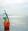 Jar of refreshing iced fruit punch over looking bright ocean