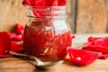 Jar of rose petal jam on a wooden table with flowers roses, selective focus Royalty Free Stock Photo