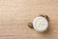Jar of shea butter, nuts and space for text on wooden background Royalty Free Stock Photo