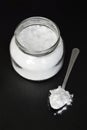 Jar and spoon with baking soda on black background Royalty Free Stock Photo