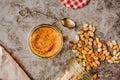 Jar and spoon of peanut butter and peanuts on dark wooden background from top view Royalty Free Stock Photo