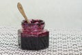 A jar with a spoon on a table with blueberry jam. Royalty Free Stock Photo