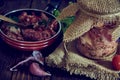 A jar of stewed meat and a frying pan on a wooden countertop. Royalty Free Stock Photo