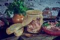 A jar of stewed meat and a frying pan on a wooden countertop. Royalty Free Stock Photo