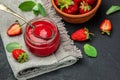 Jar of strawberry jam on dark background. Homemade strawberry marmelade and fruits. Long banner format