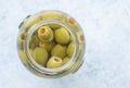 Jar of stuffed green olives in brine close up top view photo wit Royalty Free Stock Photo