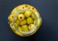 Jar of stuffed green olives in brine close up top view photo wit Royalty Free Stock Photo