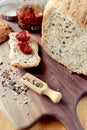 jar of sun-dried tomatoes on a crust of fresh bread. Healthy food concept. loaf of homemade whole grain bread and a cut Royalty Free Stock Photo