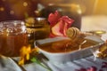 a jar of sweet honey on a table from the garden with apples in a glass jar with cheese and roses and fresh bread with