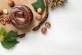 Jar with tasty chocolate spread and hazelnuts on white wooden table, flat lay. Space for text Royalty Free Stock Photo