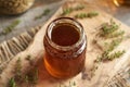 A jar of thyme syrup on a table Royalty Free Stock Photo