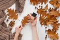 Jar with a tonal cream and oak autumn leaf in the woman`s hands. Top view. Natural beauty cosmetics concept. Autumn